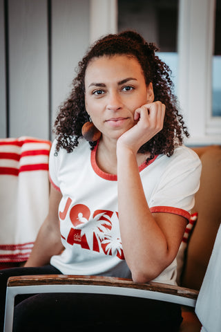 Weißes Frauen Ringer-T-Shirt von Josyland, zeigt den stilvollen Schnitt und das Logo auf der Vorderseite.