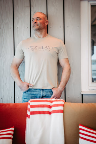 Unisex T-Shirt von Josyland, liegt flach, zeigt das Logo und das weiche Material, stilvolles Design für Alltag und Freizeit.