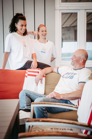 Unisex Ringer-T-Shirt von Josyland, weiße mit roten Bündchen, zeigt das T-Shirt flach liegend mit Ringer-Design.